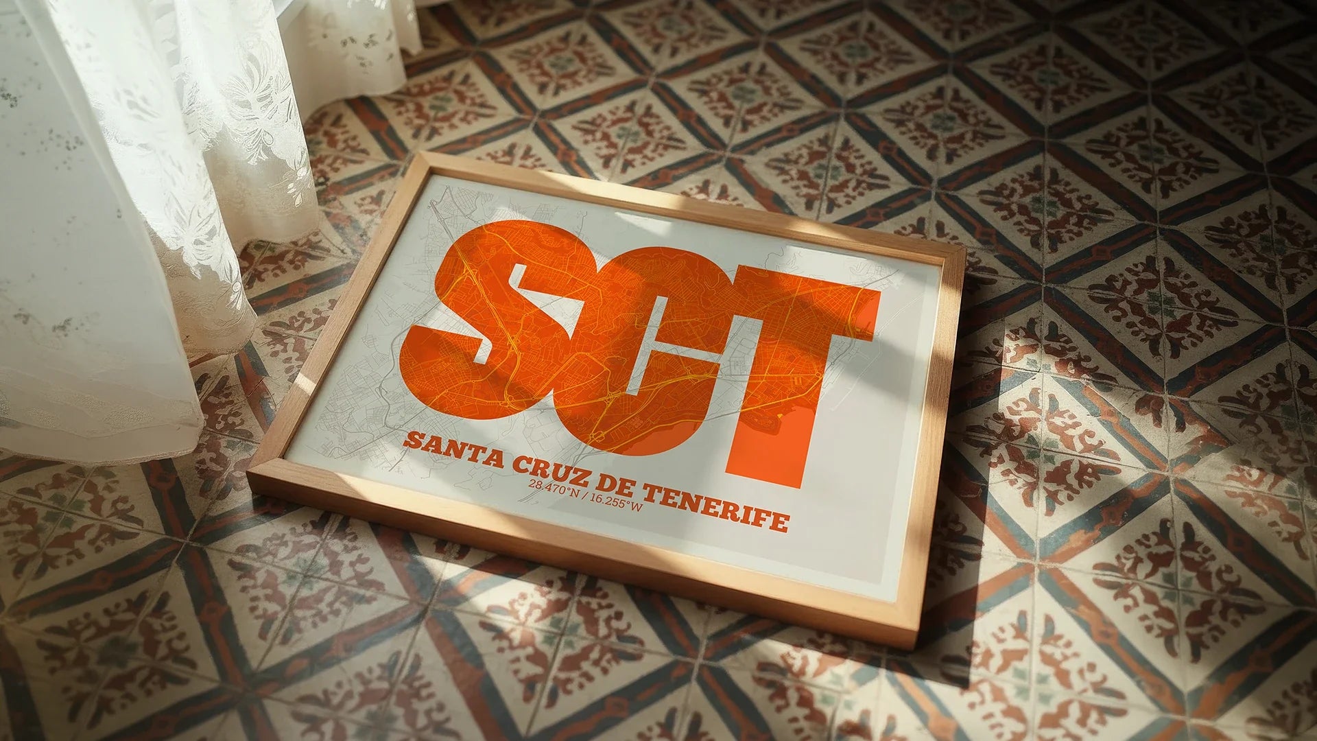 A cyan and pink map os SantaCruz de Tenerife on a mounted natural wood frame  leaning against a wall and a white floor