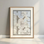 Framed A Coruña in Inseparable design, featuring the city's abbreviation in expressive typography over a detailed urban map designed in light brown and an off-white background with a white margin border in a warm lit minimalist setting