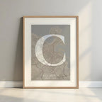 Framed A Coruña in Classic design, inspired by chiseled typography with an elegant font that creates a beautiful visual contrast designed in light brown and an off-white background with a white margin border in a warm lit minimalist setting