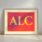 Framed Alacant in Classic design, inspired by chiseled typography with an elegant font that creates a beautiful visual contrast designed in yellow and fuchsia with a white margin border in a warm lit minimalist setting