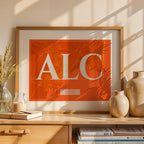 Modern interior design with a Alacant in Classic design, inspired by chiseled typography with an elegant font that creates a beautiful visual contrast designed in orange and an off-white background, displayed on a living room wall