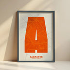 Cuadro de Albacete en mi diseño la Súper Bold, un póster tipográfico donde el mapa de la ciudad se fusiona con una tipografía extra gruesa para un impacto visual moderno diseñado en naranja y fondo blanco roto con impresión sin márgenes, apoyado contra la pared