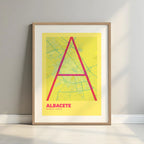 Framed Albacete in Ultralight design, a minimalist aesthetic combining urban cartography with modern, extra-thin elegant lettering designed in yellow and fuchsia with a white margin border in a warm lit minimalist setting