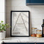 Diseño de interiores moderno con la lámina de Albacete en el diseño la Ultrafina, una estética minimalista que combina cartografía urbana con letras modernas, finas y elegantes diseñado en marrón claro y fondo blanco roto, expuesto en la pared de un salón