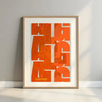 Framed Algeciras in Inseparable design, featuring the city's abbreviation in expressive typography over a detailed urban map designed in orange and an off-white background with a white margin border in a warm lit minimalist setting