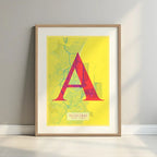 Framed Algeciras in Classic design, inspired by chiseled typography with an elegant font that creates a beautiful visual contrast designed in yellow and fuchsia with a white margin border in a warm lit minimalist setting