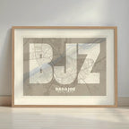 Framed Badajoz in Super Bold design, a typographic poster where the city map is overlaid with extra-thick lettering for a modern, high-impact look designed in light brown and an off-white background with a white margin border in a warm lit minimalist setting