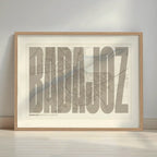 Framed Badajoz in Extra Compressed design, where the letters are tightly squeezed to fit the city's map shape designed in light brown and an off-white background with a white margin border in a warm lit minimalist setting