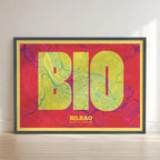Framed Bilbao in Super Bold design, a typographic poster where the city map is overlaid with extra-thick lettering for a modern, high-impact look designed in yellow and fuchsia with no border edge-to-edge print leaning against a wall