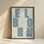 Cuadro del Born, Barcelona, en el diseño la Revoltosa, donde las letras del nombre aparecen aleatoriamente en diferentes líneas para un diseño urbano realmente original diseñado en gris azulado y fondo blanco roto con impresión sin márgenes, apoyado contra la pared
