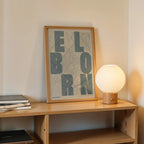 Diseño de interiores moderno con la lámina del Born, Barcelona, en el diseño la Revoltosa, donde las letras del nombre aparecen aleatoriamente en diferentes líneas para un diseño urbano realmente original diseñado en gris azulado y fondo blanco roto, expuesto en la pared de un salón
