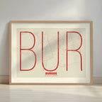 Framed Burgos in Ultralight design, a minimalist aesthetic combining urban cartography with modern, extra-thin elegant lettering designed in red and an off-white background with a white margin border in a warm lit minimalist setting