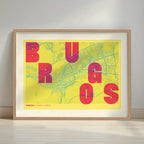 Framed Burgos in Unruled design, where the city name letters appear randomly across different lines for a truly original urban layout designed in yellow and fuchsia with a white margin border in a warm lit minimalist setting