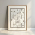 Framed Caceres in Inseparable design, featuring the city's abbreviation in expressive typography over a detailed urban map designed in light brown and an off-white background with a white margin border in a warm lit minimalist setting