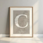 Framed Caceres in Classic design, inspired by chiseled typography with an elegant font that creates a beautiful visual contrast designed in light brown and an off-white background with a white margin border in a warm lit minimalist setting