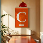 Modern interior design with a Caceres in Classic design, inspired by chiseled typography with an elegant font that creates a beautiful visual contrast designed in orange and an off-white background, displayed on a living room wall