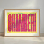 Framed Chamberi in Extra Compressed design, where the letters are tightly squeezed to fit the city's map shape designed in yellow and fuchsia with a white margin border in a warm lit minimalist setting