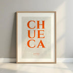 Cuadro de Cheuca, Madrid, en el diseño la Clásica, inspirado en la tipografía cincelada con una fuente elegante que crea un bonito contraste visual diseñado en naranja y fondo blanco roto con margen en un entorno minimalista con iluminación cálida