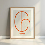 Framed Chueca, Madrid, in Ultralight design, a minimalist aesthetic combining urban cartography with modern, extra-thin elegant lettering designed in orange and an off-white background with a white margin border in a warm lit minimalist setting