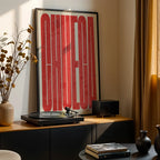 Diseño de interiores moderno con la lámina de Chueca, Madrid, en el diseño la Extra Comprimida, donde las letras se ajustan al ancho del mapa de la ciudad diseñado en rojo y fondo blanco roto, expuesto en la pared de un salón