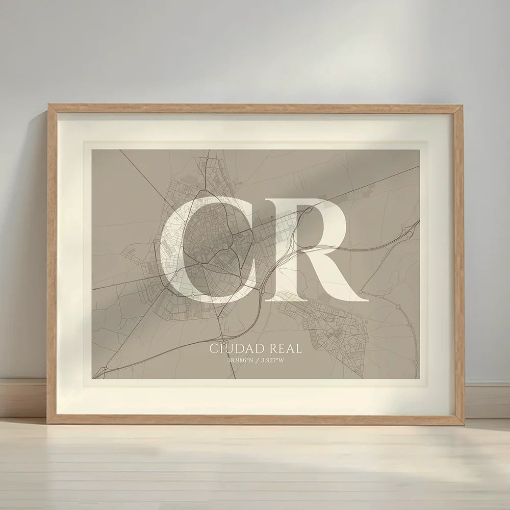 Framed Ciudad Real in Classic design, inspired by chiseled typography with an elegant font that creates a beautiful visual contrast designed in light brown and an off-white background with a white margin border in a warm lit minimalist setting