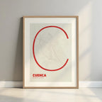 Framed Cuenca in Ultralight design, a minimalist aesthetic combining urban cartography with modern, extra-thin elegant lettering designed in red and an off-white background with a white margin border in a warm lit minimalist setting