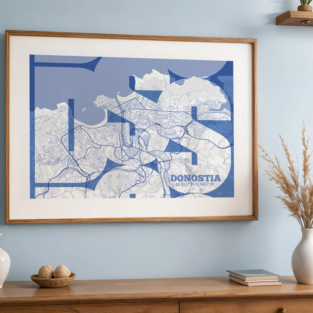 Diseño de interiores moderno con la lámina de Donostia en mi diseño la Inseparable, una visión artística con una tipografía expresiva que muestra la abreviatura del nombre sobre el mapa detallado diseñado en azul marino y blanco, expuesto en la pared de un salón