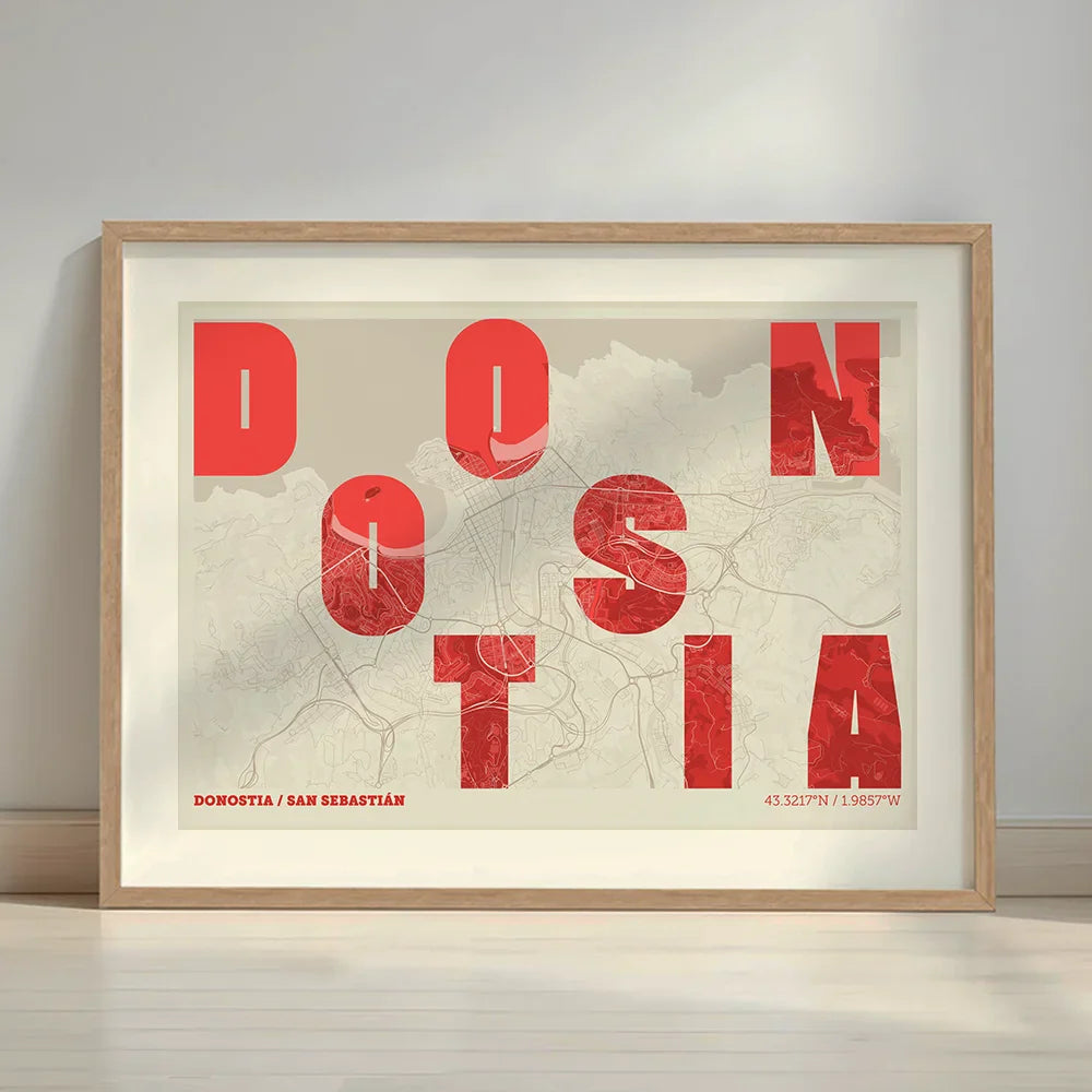 Framed Donostia in Unruled design, where the city name letters appear randomly across different lines for a truly original urban layout designed in red and an off-white background with a white margin border in a warm lit minimalist setting