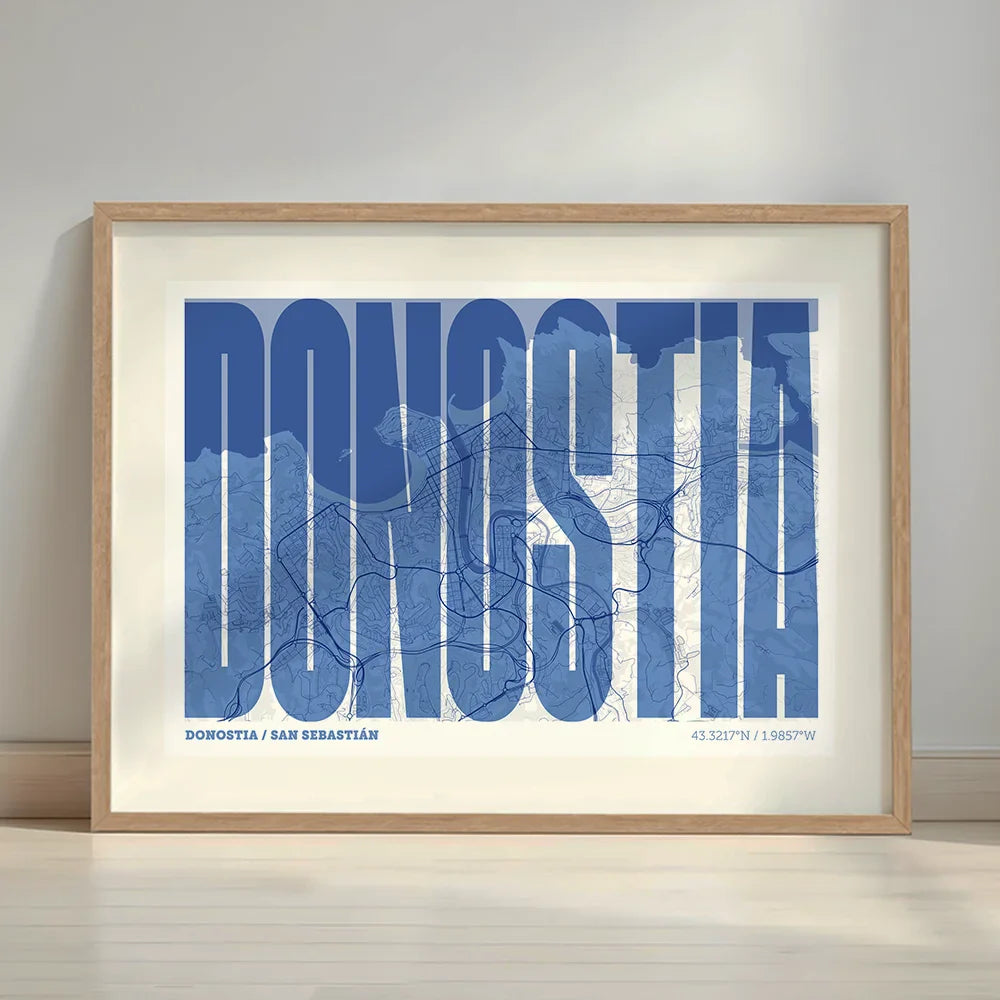 Cuadro de Donostia en el diseño la Extra Comprimida, donde las letras se ajustan al ancho del mapa de la ciudad diseñado en azul marino y blanco con margen en un entorno minimalista con iluminación cálida