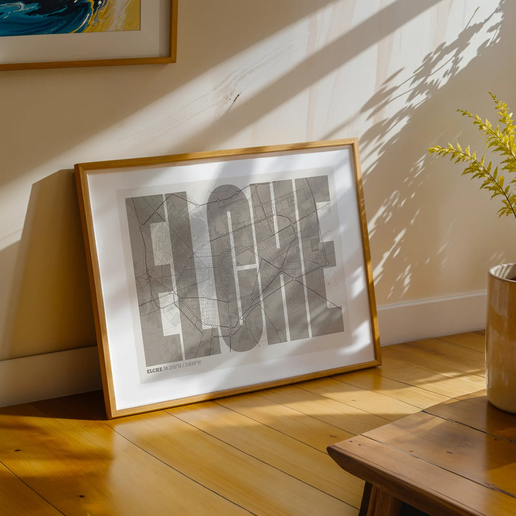 Diseño de interiores moderno con la lámina de Elche en el diseño la Extra Comprimida, donde las letras se ajustan al ancho del mapa de la ciudad diseñado en marrón claro y fondo blanco roto, expuesto en la pared de un salón