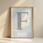 Framed Fuerteventura in Classic design, inspired by chiseled typography with an elegant font that creates a beautiful visual contrast designed in light brown and an off-white background with no border edge-to-edge print leaning against a wall