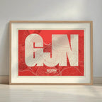 Framed Gijon in Super Bold design, a typographic poster where the city map is overlaid with extra-thick lettering for a modern, high-impact look designed in red and an off-white background with a white margin border in a warm lit minimalist setting