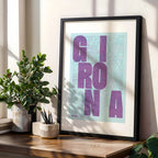Modern interior design with a Girona in Unruled design, where the city name letters appear randomly across different lines for a truly original urban layout designed in purple and light blue, displayed on a living room wall
