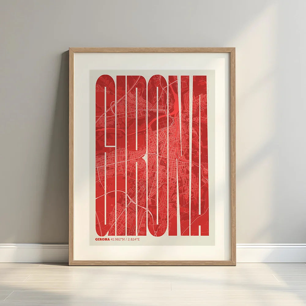 Framed Girona in Extra Compressed design, where the letters are tightly squeezed to fit the city's map shape designed in red and an off-white background with a white margin border in a warm lit minimalist setting