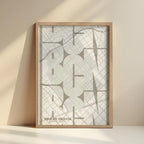 Framed Gracia Quarter in Inseparable design, featuring the city's abbreviation in expressive typography over a detailed urban map designed in light brown and an off-white background with no border edge-to-edge print leaning against a wall