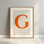Framed Gracia Quarter in Classic design, inspired by chiseled typography with an elegant font that creates a beautiful visual contrast designed in orange and an off-white background with a white margin border in a warm lit minimalist setting