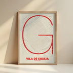 Framed Gracia Quarter in Ultralight design, a minimalist aesthetic combining urban cartography with modern, extra-thin elegant lettering designed in red and an off-white background with no border edge-to-edge print leaning against a wall