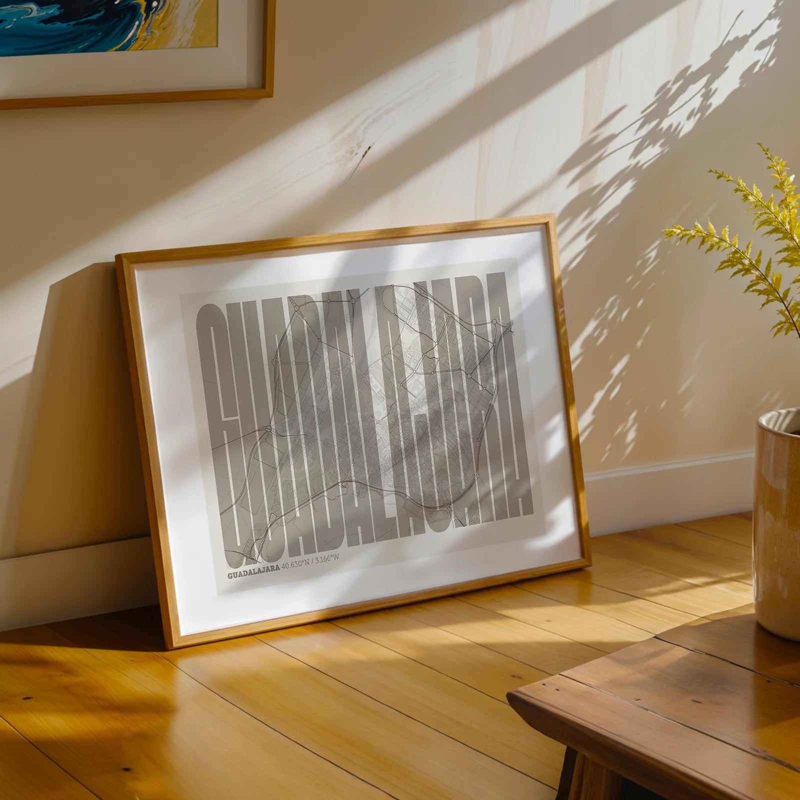 Modern interior design with a Guadalajara in Extra Compressed design, where the letters are tightly squeezed to fit the city's map shape designed in light brown and an off-white background, displayed on a living room wall