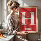 Diseño de interiores moderno con la lámina de Huesca en el diseño la Clásica, inspirado en la tipografía cincelada con una fuente elegante que crea un bonito contraste visual diseñado en rojo y fondo blanco roto, expuesto en la pared de un salón