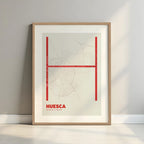 Framed Huesca in Ultralight design, a minimalist aesthetic combining urban cartography with modern, extra-thin elegant lettering designed in red and an off-white background with a white margin border in a warm lit minimalist setting
