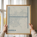 Diseño de interiores moderno con la lámina de Huesca en el diseño la Ultrafina, una estética minimalista que combina cartografía urbana con letras modernas, finas y elegantes diseñado en gris azulado y fondo blanco roto, expuesto en la pared de un salón