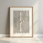 Framed Huesca in Extra Compressed design, where the letters are tightly squeezed to fit the city's map shape designed in light brown and an off-white background with a white margin border in a warm lit minimalist setting
