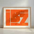 Framed Ibiza in Inseparable design, featuring the city's abbreviation in expressive typography over a detailed urban map designed in orange and an off-white background with a white margin border in a warm lit minimalist setting