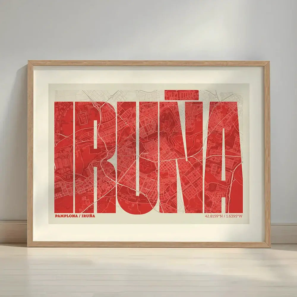 Framed Iruña in Extra Compressed design, where the letters are tightly squeezed to fit the city's map shape designed in red and an off-white background with a white margin border in a warm lit minimalist setting