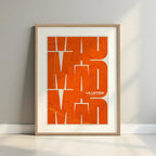 Framed La Latina, Madrid, in Inseparable design, featuring the city's abbreviation in expressive typography over a detailed urban map designed in orange and an off-white background with a white margin border in a warm lit minimalist setting