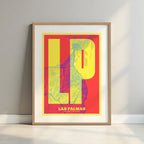 Framed Las Palmas in Super Bold design, a typographic poster where the city map is overlaid with extra-thick lettering for a modern, high-impact look designed in yellow and fuchsia with a white margin border in a warm lit minimalist setting