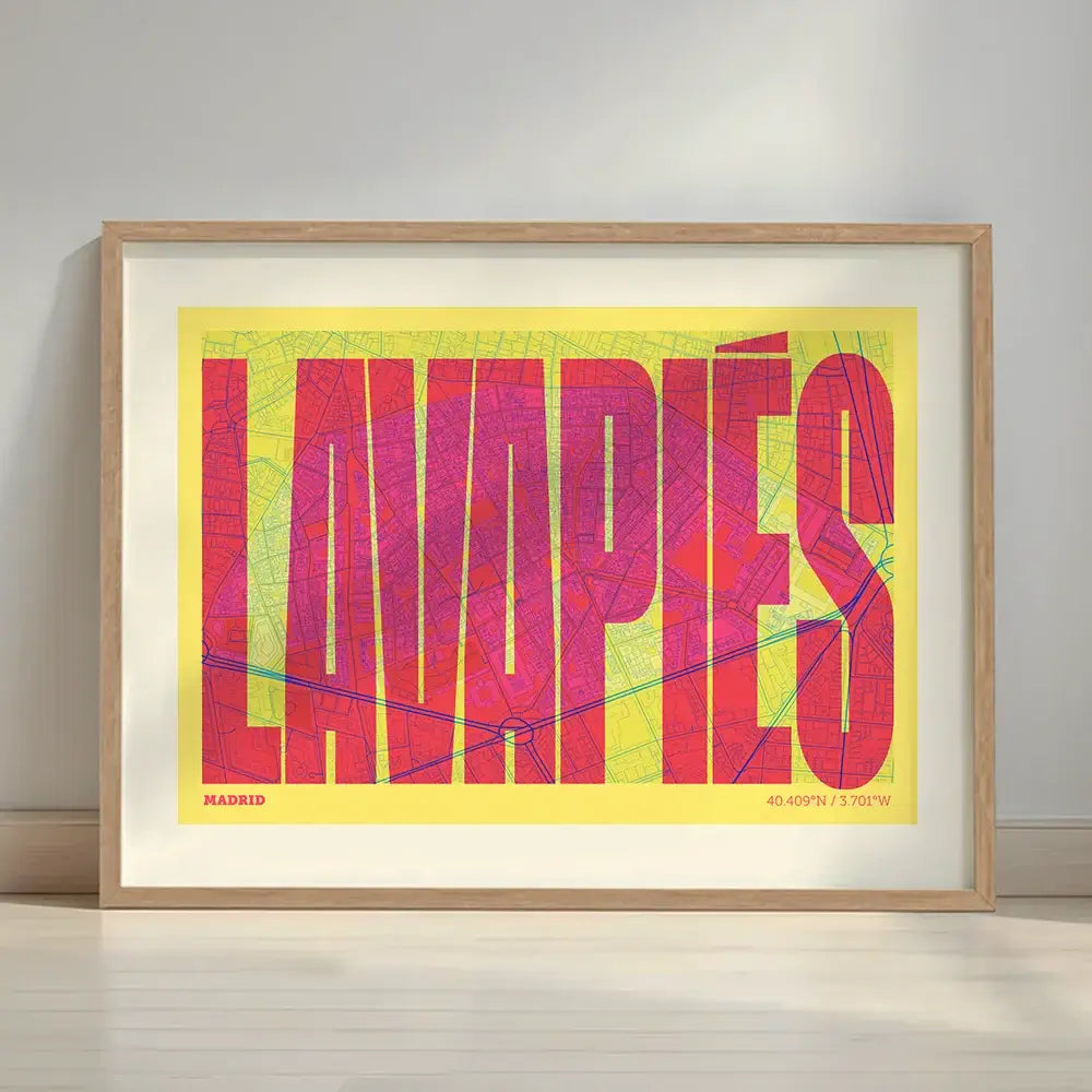 Framed Lavapies, Madrid, in Extra Compressed design, where the letters are tightly squeezed to fit the city's map shape designed in yellow and fuchsia with a white margin border in a warm lit minimalist setting