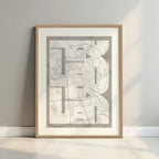 Framed Leon in Inseparable design, featuring the city's abbreviation in expressive typography over a detailed urban map designed in light brown and an off-white background with a white margin border in a warm lit minimalist setting