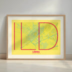 Framed Lerida in Ultralight design, a minimalist aesthetic combining urban cartography with modern, extra-thin elegant lettering designed in yellow and fuchsia with a white margin border in a warm lit minimalist setting