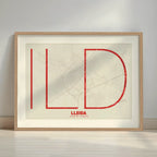 Framed Lleida in Ultralight design, a minimalist aesthetic combining urban cartography with modern, extra-thin elegant lettering designed in red and an off-white background with a white margin border in a warm lit minimalist setting